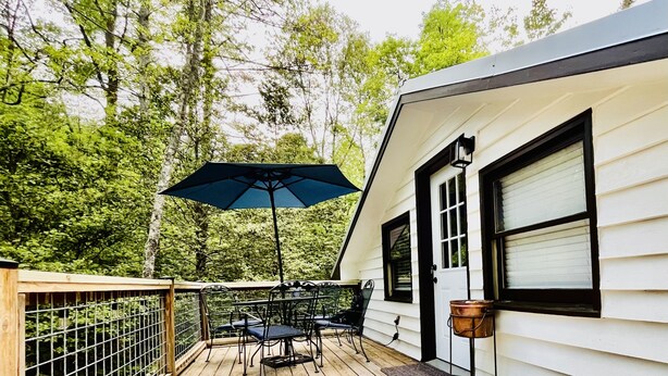 A deck with outdoor furniture and a hanging bucket.