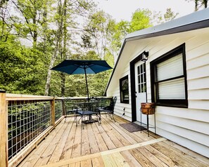 A deck with outdoor furniture and a hanging bucket. - River Rock Cabin - Private Escape - ON the Etowah River! Private decks/firepits! (Dahlonega)