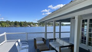 A deck with outdoor seating and a view of a lake. - Lake Life Retreat 3BR Home w/ 2 Kitchens & Docks (Warwick)