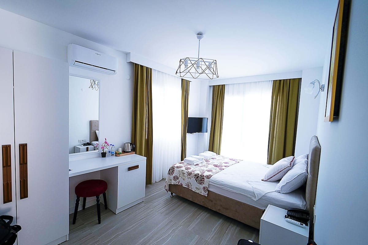 A modern hotel room with a bed, desk, and chair.