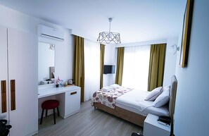 Une chambre d’hôtel moderne, équipée d’un lit, d’un bureau et d’une chaise.