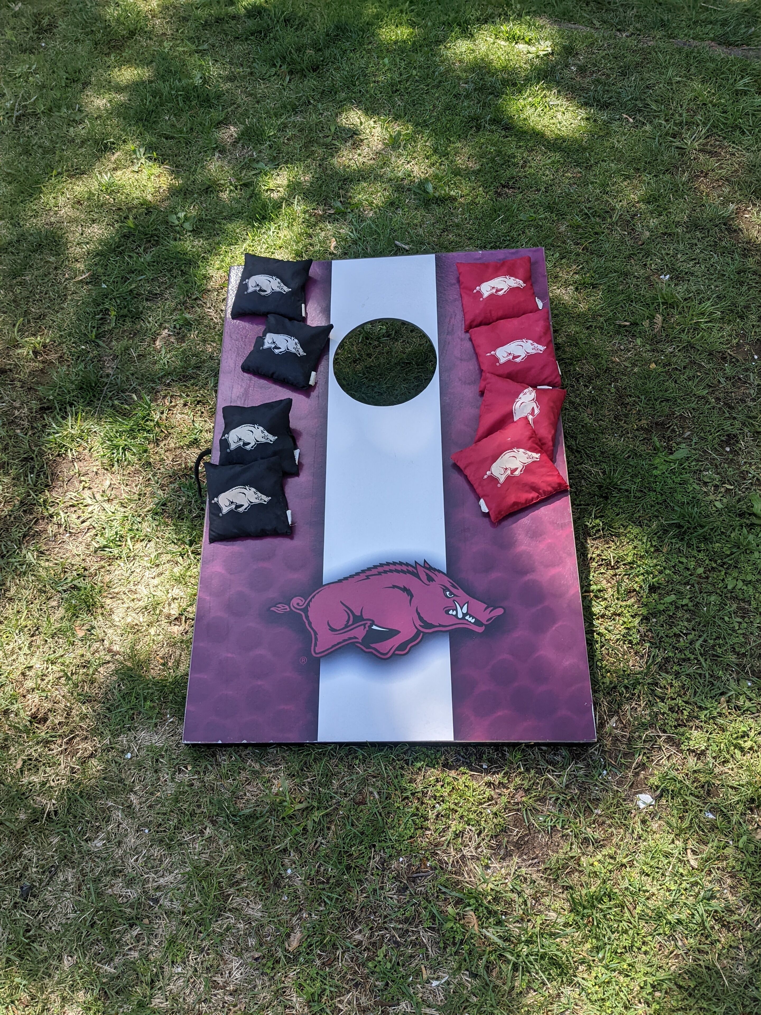 En picnic med et borddække med et logo af et griseansigt, omgivet af sorte og røde puder med grise motiver.