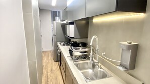 A modern kitchen with stainless steel appliances, a built-in dishwasher, and a sleek countertop.