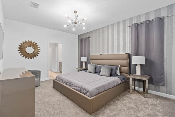 Un dormitorio moderno con una cama grande, lámparas de noche, un espejo y una lámpara en el techo.