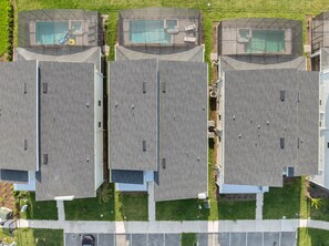 Un moderno complejo de apartamentos con varias unidades, cada una con balcón y un pequeño jardín.