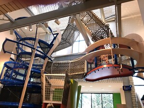 A multi-level indoor play area with various climbing structures and netted sections. - Condo with king bed, walk to Microsoft, park (Bellevue)