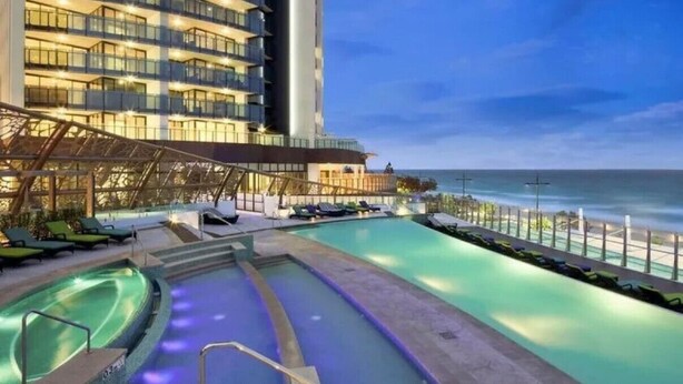 A hotel pool area with a large pool, a smaller hot tub, and lounge chairs. - Soul 5 Star Amazing Beachfront 180 Views! (Surfers Paradise)