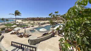 Um resort com área de piscina, espreguiçadeiras e vista para a praia e o oceano.