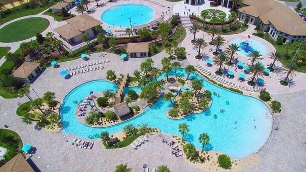 Vista aérea de un resort con múltiples piscinas, palmeras y zonas de descanso.