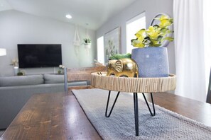 Relax in this stylish living room with a sofa, flat-screen TV, and decorative touches.