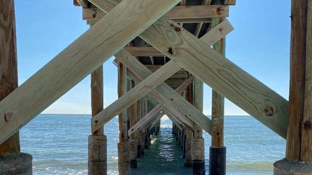 Una estructura de muelle de madera con una vista despejada del océano.