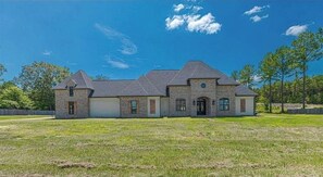 Stunning two-story house with a central entrance and symmetrical design, set amidst a beautifully manicured lawn.