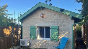 A stone building with a pitched roof, a window with shutters, and a blue chair outside. - Landes house Dax (Dax)