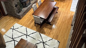 A spacious living area with a fireplace, wooden dining table, and a staircase leading to another level. - Coldwater Lake Spacious Lake Drive Getaway (Coldwater)