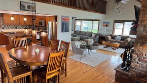 A spacious living area with a dining table, sofas, and a fireplace. - Coldwater Lake Spacious Lake Drive Getaway (Coldwater)