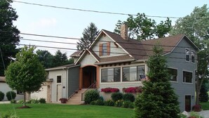 A two-story house with a front porch, a garage, and a well-maintained lawn. - Coldwater Lake Spacious Lake Drive Getaway (Coldwater)