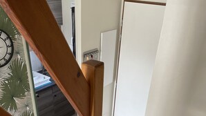 En trætrap med udsigt til et badeværelse og en dør i baggrunden.