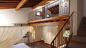 A room with a bed, a window with curtains, a wooden staircase, and a white wardrobe. - Villa Consolata, Large country villa with pool (Reggello)