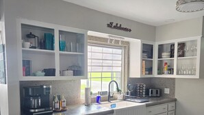 A modern kitchen with white cabinetry, a granite countertop, and a built-in dishwasher. - LAKEVIEW Hot Tub Retreat Near Wineries! (Silver Creek)
