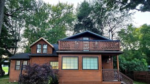 A two-story wooden house with a balcony, large windows, and a front porch. - LAKEVIEW Hot Tub Retreat Near Wineries! (Silver Creek)