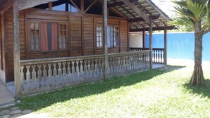 A wooden building with a porch and a palm tree. - Heated pool **FREE** + Air conditioning + 300MB Vivo fiber internet, Riviera Beach (Bertioga)