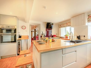 A modern kitchen with a central island, built-in ovens, and a dining area with benches. - 5 bedroom accommodation in Folly Gate, near Okehampton (Folly Gate, near Okehampton)