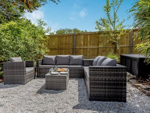 A wicker outdoor seating area with cushions, a coffee table, and a hot tub. - 5 bedroom accommodation in Folly Gate, near Okehampton (Folly Gate, near Okehampton)