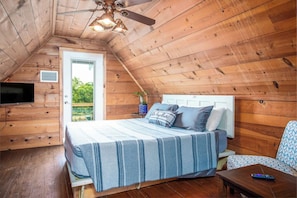 A TV and a comfy queen-sized bed create a restful sleeping nook in the second bedroom. - Old Fellows Farmhouse | 2BR with Country Views (Kerrville)