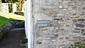 A stone wall with a sign indicating 'Gardener's Cottage'. - The Gardeners Cottage -  Retreat Group (Pitlochry)