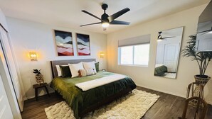A bedroom with a bed, a ceiling fan, a large mirror, and artwork on the wall. - Hillside Home: Amazing Views w/ Big Deck 5 Min. From Downtown + Trailheads! (Flagstaff)