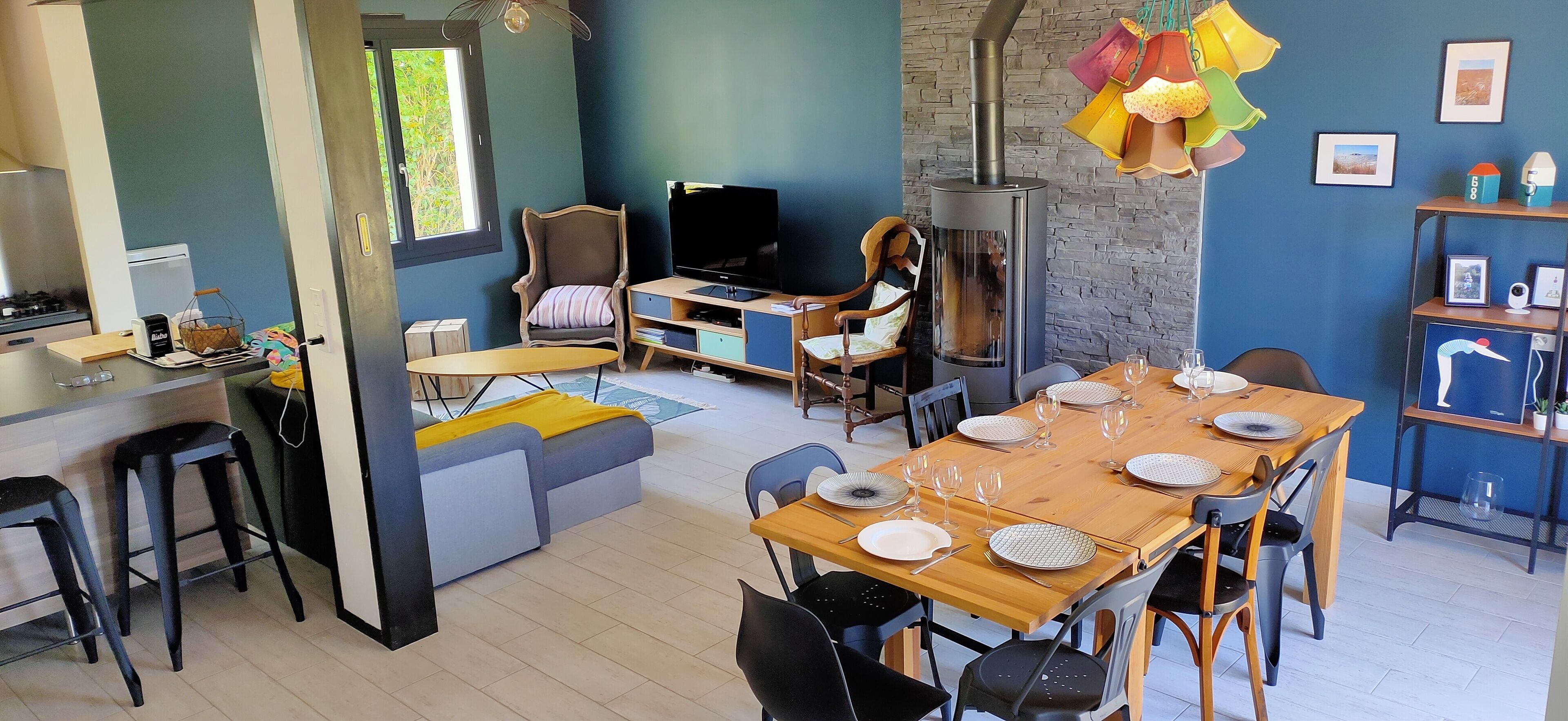 A modern living space with a dining area, kitchen, and seating.