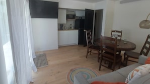 A compact living space with a kitchenette, dining area, and a sofa with a colorful rug. - Attached Unit, a few minute walk from the Beach (Santa Barbara)