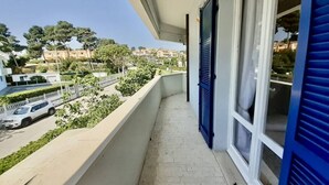 A balcony with a view of a residential street, a white car parked on the street, and a clear blue sky. - M318 - Marcelli, new comfortable three-room apartment by the sea (Marcelli)