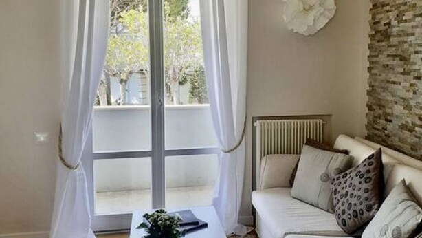 A room with a large window, a white sofa, and a radiator. - M318 - Marcelli, new comfortable three-room apartment by the sea (Marcelli)