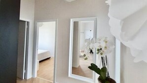A room with a bed, a mirror, and a potted plant. - M318 - Marcelli, new comfortable three-room apartment by the sea (Marcelli)