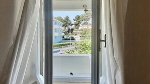 A view through a window with curtains, revealing a balcony with a railing and a clear sky. - M318 - Marcelli, new comfortable three-room apartment by the sea (Marcelli)