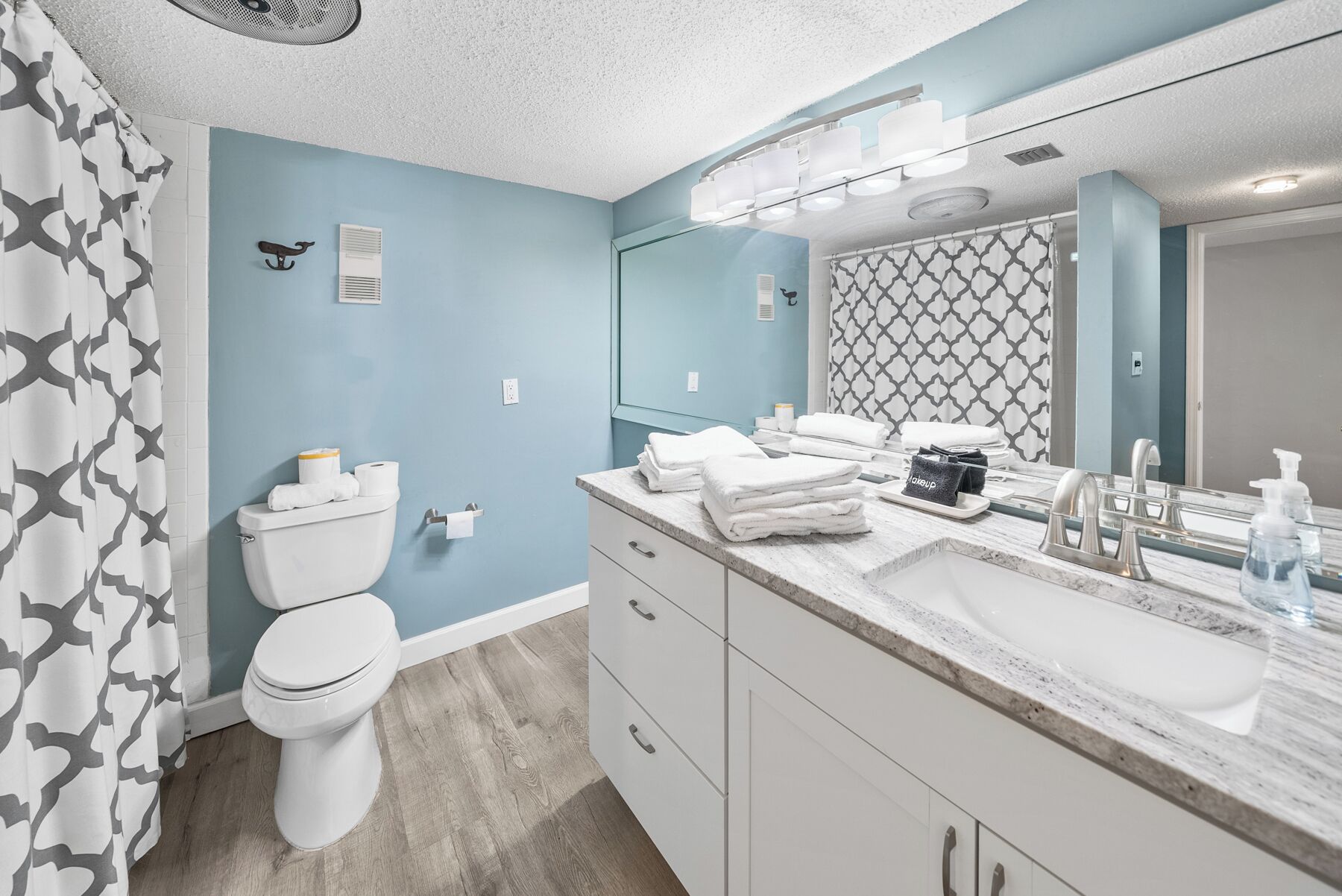 A modern bathroom with a toilet, sink, and mirror.