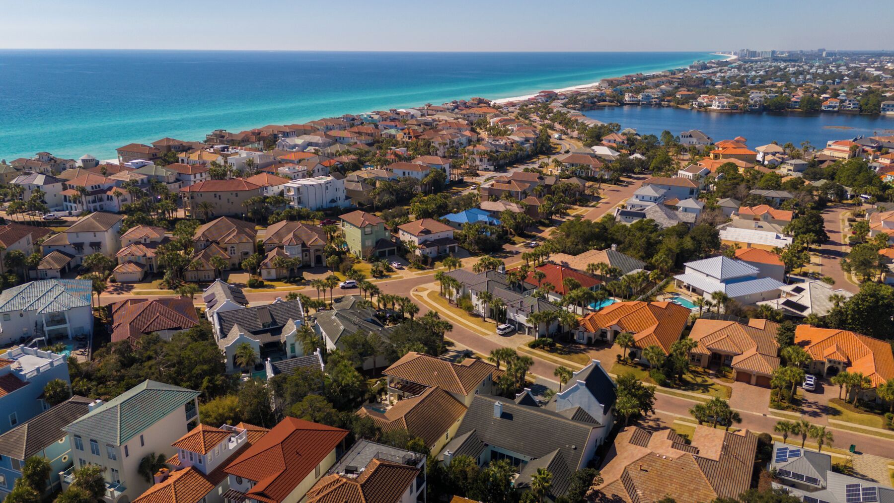 Et kystnært boligområde med huse, veje og en strand.