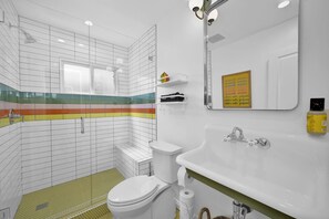 Ein modernes Badezimmer mit Toilette, Waschbecken und Duschbereich.