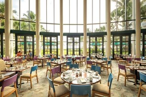 Enjoy meals in this serene dining area with views of lush palm trees and greenery.