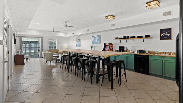 Une cuisine spacieuse avec un grand îlot central, des tabourets de bar et des meubles de couleur verte.