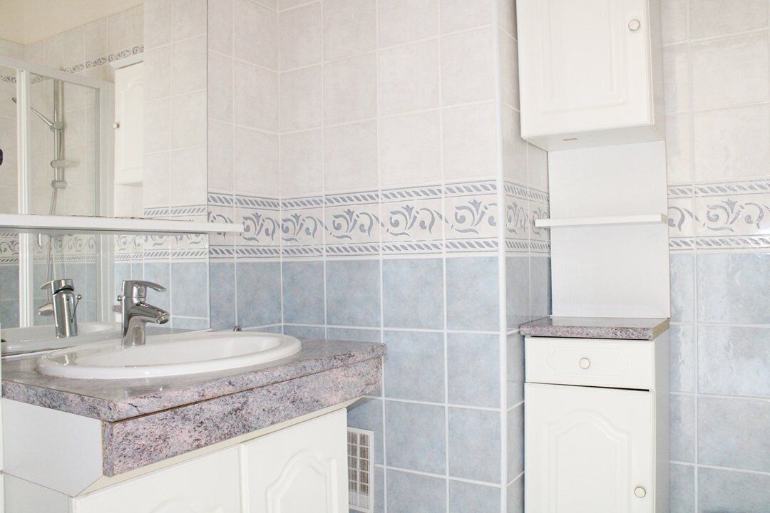 A bathroom with a sink, mirror, and cabinets.