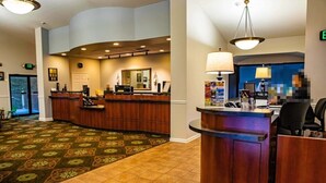 A hotel lobby with a reception desk, a large mirror, and a patterned carpet. - Laurel Crest™ - 2 Bedroom Townhome (Pigeon Forge)