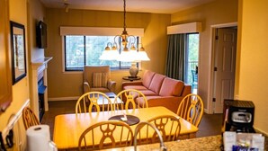 A compact hotel room with a dining area, a sofa, and a television. - Laurel Crest™ - 2 Bedroom Townhome (Pigeon Forge)
