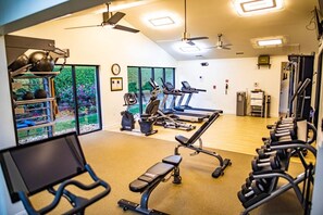 A gym with exercise equipment, large windows, and a ceiling fan. - Pigeon Forge | Friends' Outdoor Escape | Hiking + Pool | 2BR Townhome (Pigeon Forge)