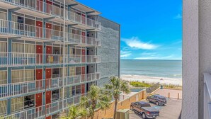 Een hotel met meerdere verdiepingen en balkons met uitzicht op het strand.