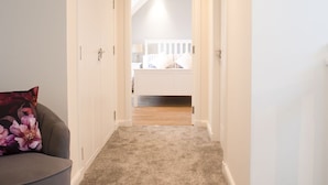 A narrow hallway with a carpeted floor leading to a bedroom with a bed and a nightstand. - Wonderful private villa for 6 guests with WIFI, TV, pets allowed and panoramic view (Tarskavaig)