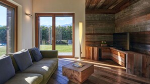 A modern living room with a wooden ceiling, a sofa, a coffee table, and a TV. - Wonderful private villa with A/C, hot tub, WIFI, private pool, TV, patio and pets allowed (Colico)