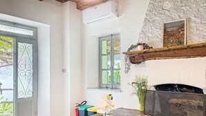 A room with a wooden table, a fireplace, a window, and a door. - Lovely apartment in villa for 2 guests with WIFI, A/C, TV, terrace and pets allowed (Vendrogno)