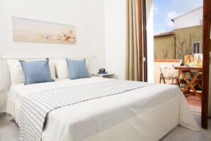 Ein Hotelzimmer mit Bett, Nachttisch und Blick ins Freie.